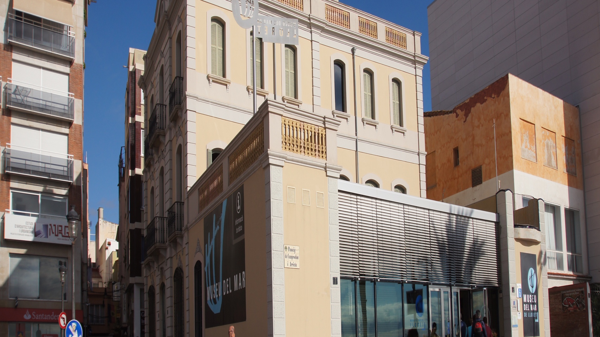 Façade of the Museu del Mar building in Lloret de Mar, a light beige modernista house with a main balcony and discreet museum signage on a central town street
